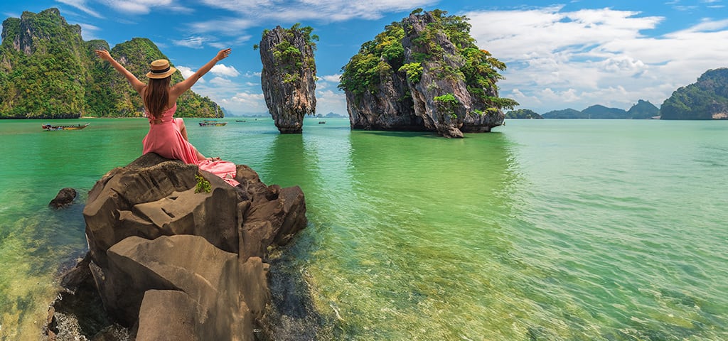 Oceania Cruises summer and winter sale featuring scenic tropical limestone cliffs and turquoise waters, advertising up to 40% off with free excursions and gourmet dining.